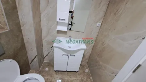 Kupatilo opremljeno umivaonikom sa ormarićem, ogledalom i toaletom. - image 5