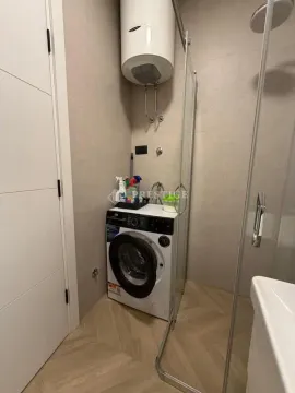 Smaller bathroom with a walk-in shower, washing machine, and water heater. - image 9