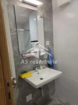 View of the bathroom with a sink, mirror, and tiles. - image 15