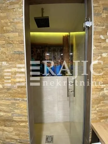 A view of the shower cabin with a glass screen and a decorative wall.