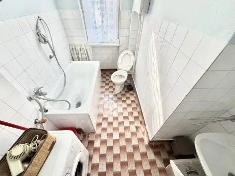 Bathroom equipped with a bathtub, toilet, washbasin, and washing machine. - image 4