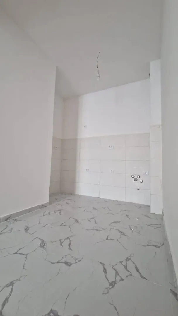 Nenameštena prostorija sa pločicama na podu i zidovima.