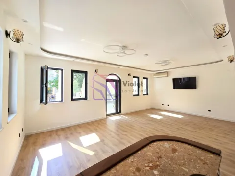 Spacious living room with wooden flooring, large windows and a wall-mounted TV. - image 16