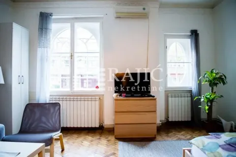 Furnished bedroom with two windows and a TV dresser. - image 4