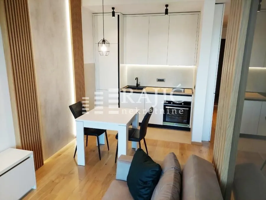 Modern living room with dining area and kitchen in the background.