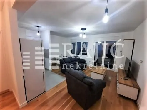 Living room with sofa set and dining area in the background.