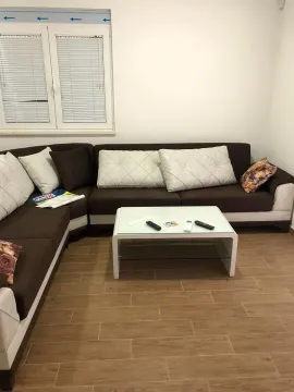 Living room with a sectional sofa and a coffee table. - image 9