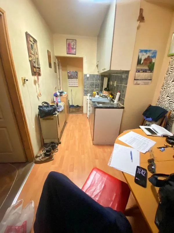 Manja kuhinja sa sudoperom, elementima i trpezarijskim stolom u prvom planu.