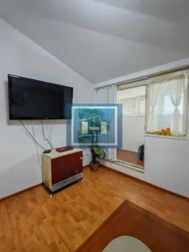 Living room with wooden flooring, wall-mounted TV, and access to the terrace. - image 3