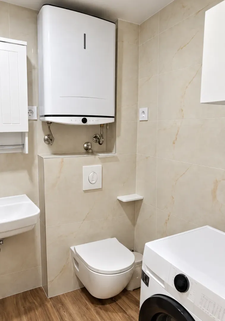Modernly equipped bathroom with a built-in toilet, sink, and water heater.