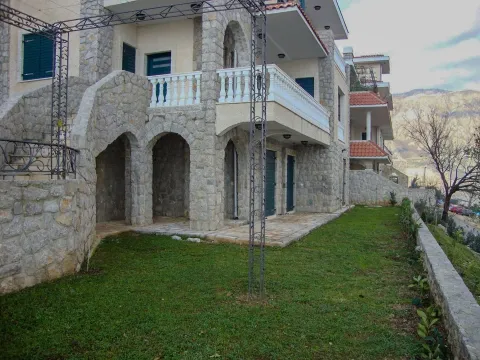 Eksterijer kuće sa kamenom fasadom, balkonom i uređenim dvorištem. - image 8