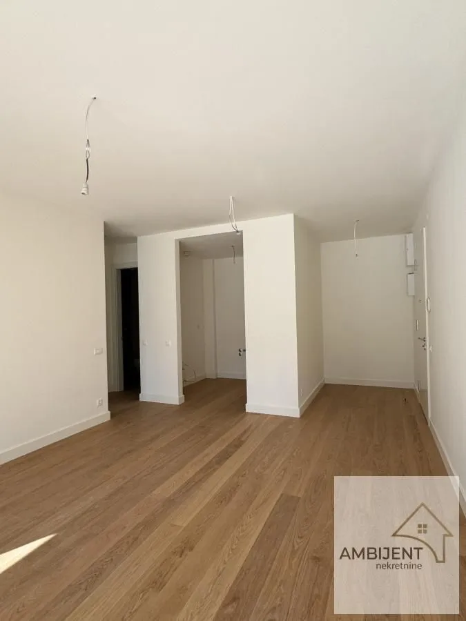 Empty room with wooden flooring and white walls.