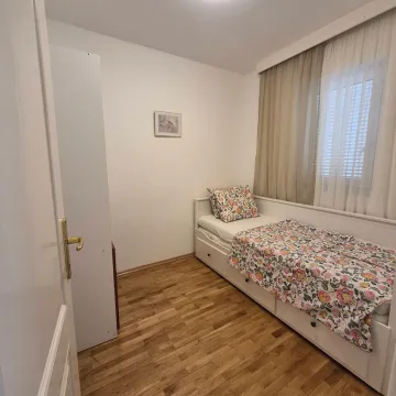 Small bedroom with a bed and wooden flooring. - image 8