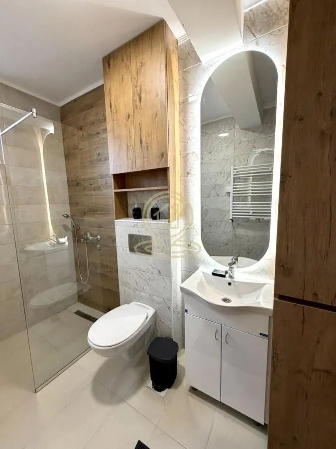 Modern bathroom equipped with a walk-in shower, washbasin, and wall-hung toilet.