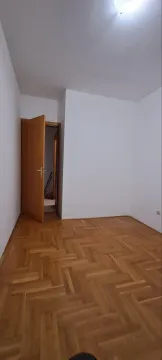 Prazna soba sa parketom i otvorenim drvenim vratima. - image 4