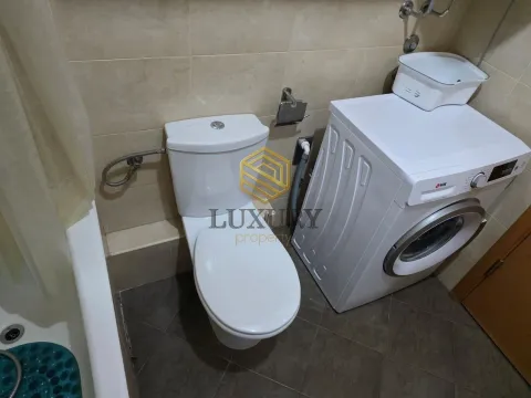 Smaller bathroom with sanitary fixtures, bathtub, and washing machine. - image 11