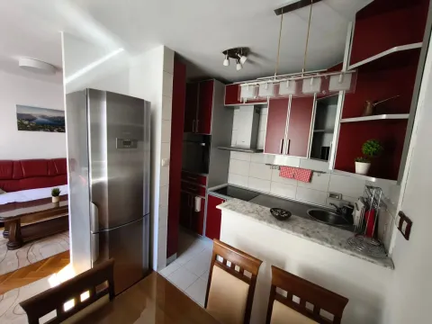 Kuhinja opremljena crvenim elementima i ugradnim kućnim aparatima. - image 5
