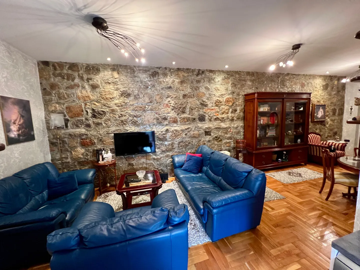 Spacious living room with a stone accent wall and seating furniture.