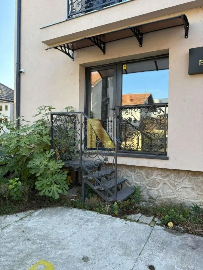 Entrance to the building with stairs and a decorative railing.