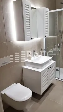 Modern bathroom with white furniture, washbasin, and shower cabin. - image 8