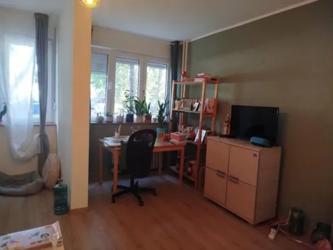 Dnevna soba sa radnim kutkom i policom za knjige pored prozora. - image 2