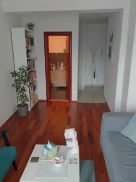 Pogled na dnevni boravak sa trosedom, stočićem i policom za knjige. - image 4
