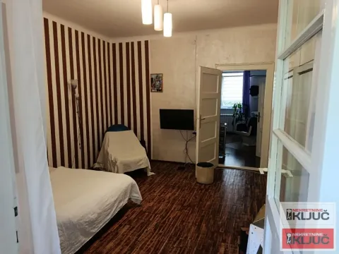 Spavaća soba sa krevetom i prugastim tapetama. - image 6
