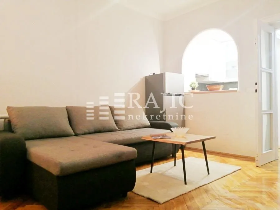 Living room with a sofa and wooden coffee table.