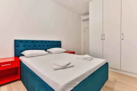 Bedroom with a double bed, red nightstands, and a large white wardrobe. - image 8
