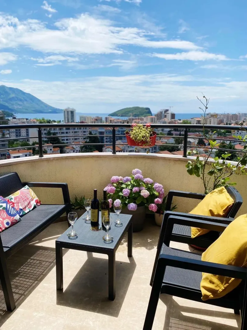 Furnished terrace with seating set and view of the city and sea.