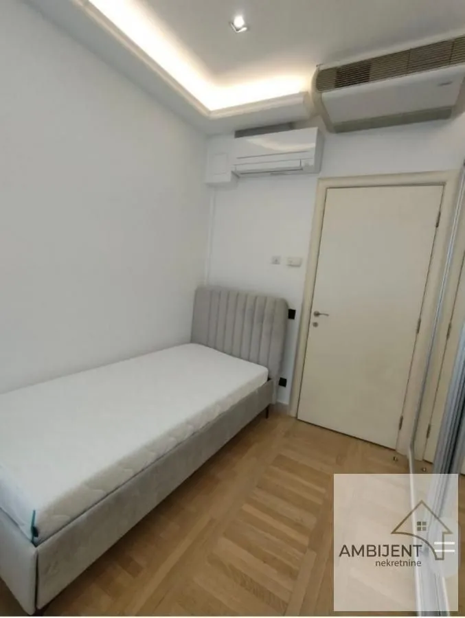 Smaller bedroom with a bed and an air conditioning unit.