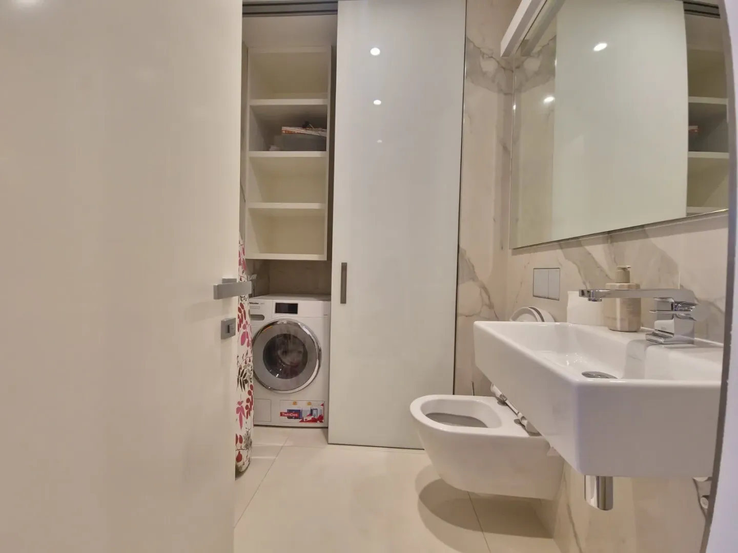 Modern equipped bathroom with a washing machine and built-in units.