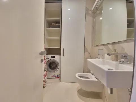 Modern equipped bathroom with a washing machine and built-in units. - image 20