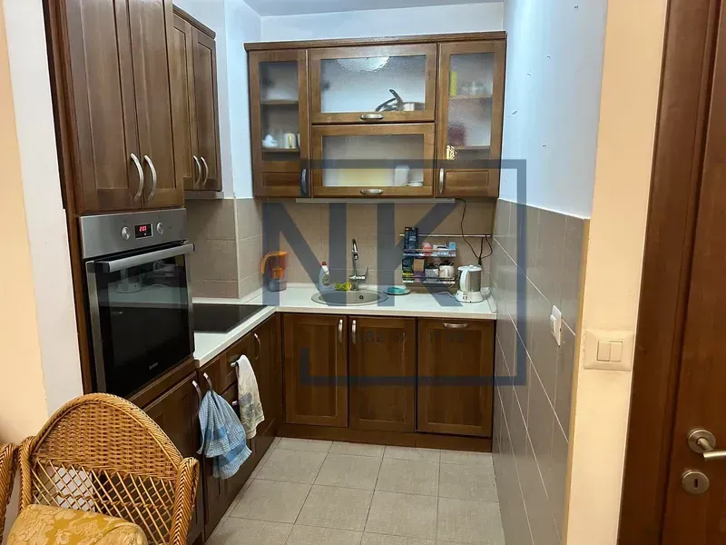 Manja kuhinja sa drvenim elementima i ugrađenom rernom.
