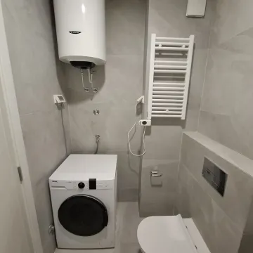 Manje kupatilo sa sijem pločicama, bojlerom, veš mašinom i toaletom. - image 4