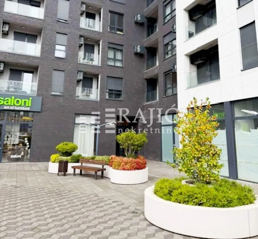 Courtyard in front of a modern residential building with landscaped greenery.