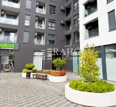 Courtyard in front of a modern residential building with landscaped greenery. - image 14