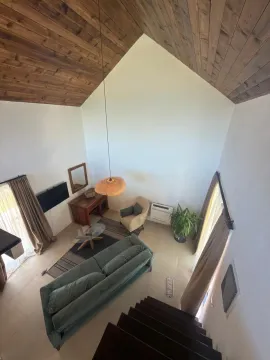 High-angle view of the living room with a high vaulted wooden ceiling. - image 7