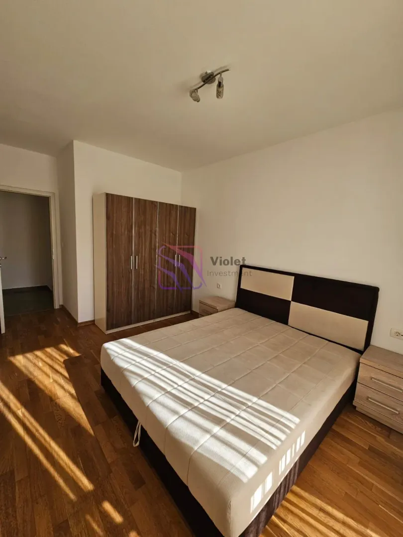 Namještena spavaća soba sa bračnim krevetom, ormarom i noćnim stočićima.