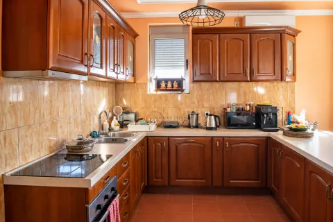 Kitchen with wooden cabinetry, countertops, and built-in appliances. - image 5
