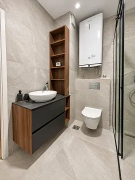Modernly equipped bathroom with a washbasin, toilet, and shower cabin. - image 12
