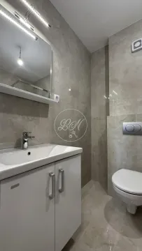 Moderno kupatilo opremljeno umivaonikom sa ormarićem, ogledalom i toaletom. - image 15
