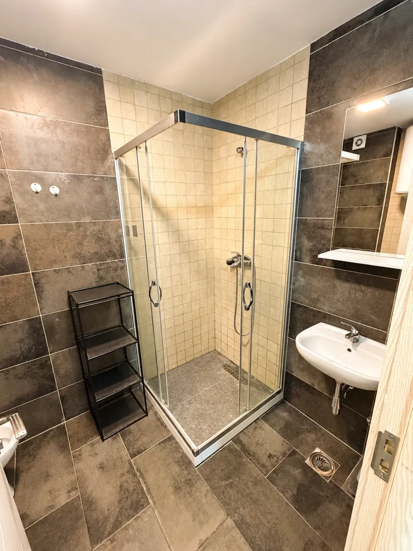 Modern bathroom equipped with a shower cabin and washbasin.