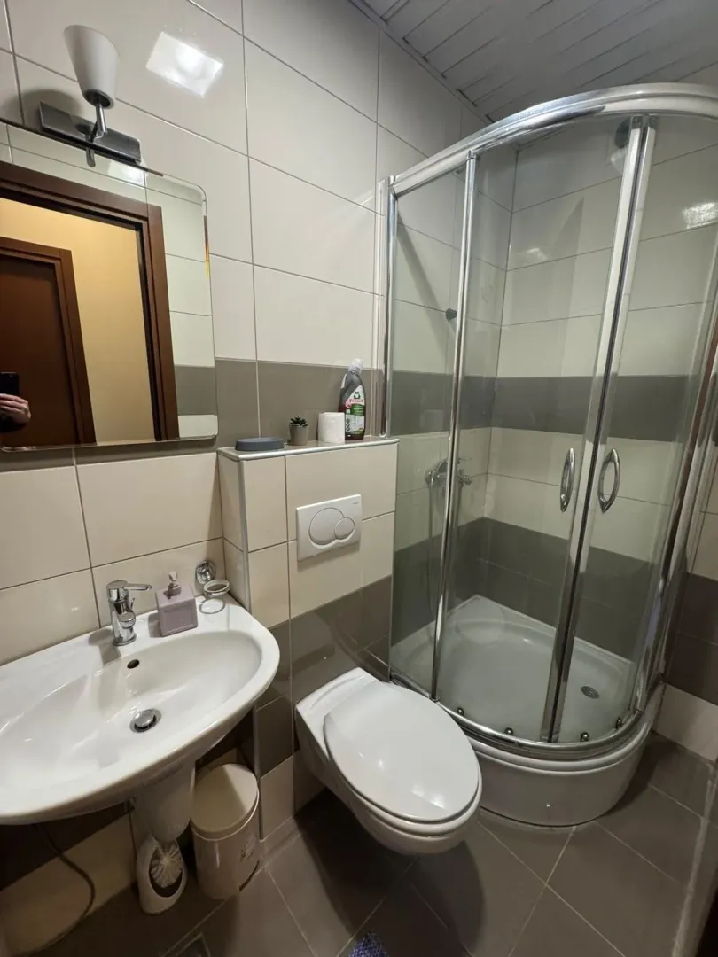Manje kupatilo sa tuš kabinom, umivaonikom i WC šoljom.