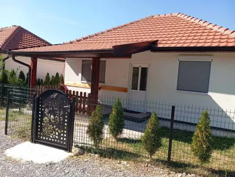View of the entrance and yard of a single-story house with a tiled roof and a fence. - image 11