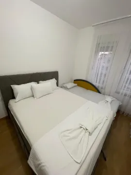 Spavaća soba sa bračnim krevetom i prozorom sa bijelim zavjesama. - image 5