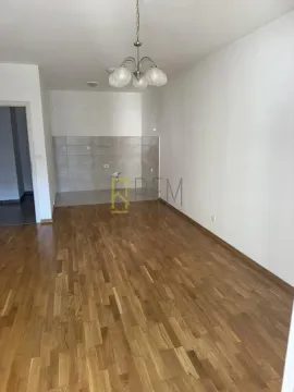 Prazna dnevna soba sa drvenim parketom i pripremljenim dijelom za kuhinju. - image 5