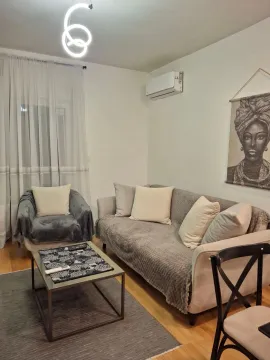 Comfortable living room with a sofa, armchair, and coffee table. - image 2