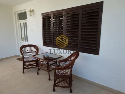 Covered terrace with seating furniture in front of a white facade. - image 11