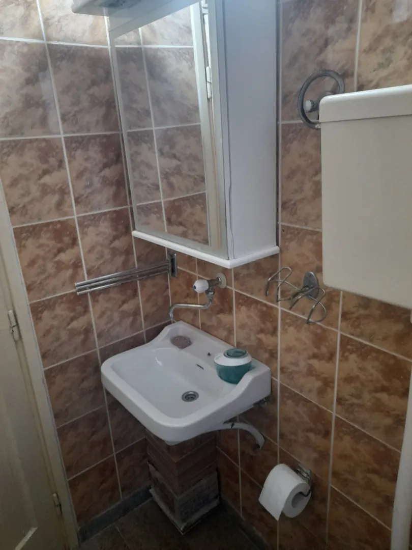 Jednostavno kupatilo sa lavaboom i ogledalom.